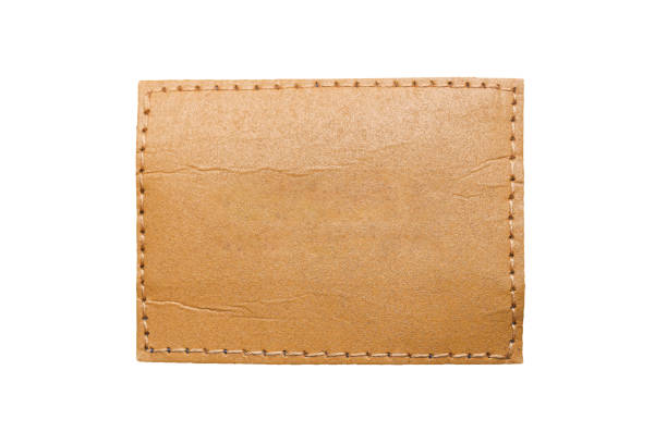 istock Brown leather belt strap closeup isolated on white. Brown stitched leather seam frame label tag isolated on white. 2199742100