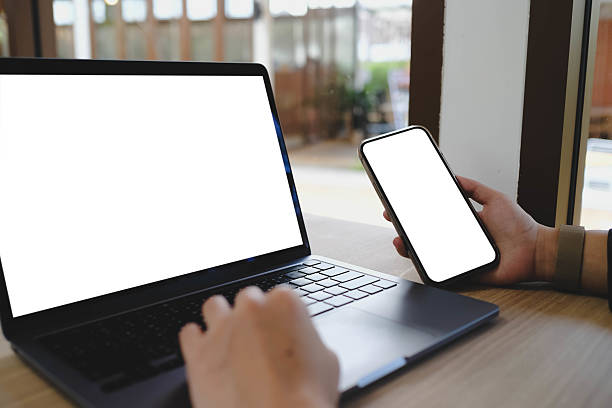 istock A white blank screen for hand typing text,using laptop and mobile phone contact business searching information in workplace on desk at cafe. 2199753194