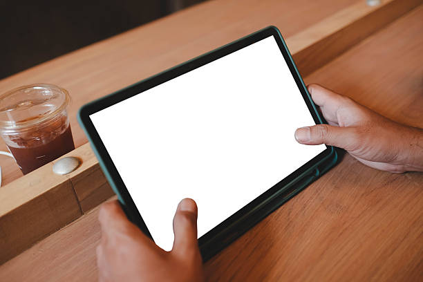 Mockup image of a man holding black tablet pc with blank white screen in cafe