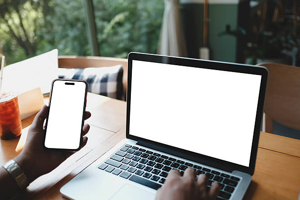 istock A white blank screen for hand typing text,using laptop and mobile phone contact business searching information in workplace on desk at cafe. 2199753237