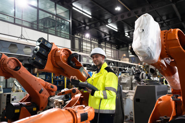 istock Business or engineer Caucasian male checking with control a robot arm with remote computer 2199754714