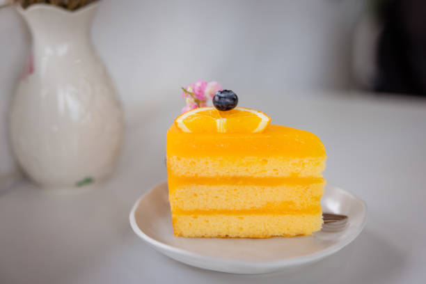 Lemon cream cake on a white plate. Top view. On a white wooden background.