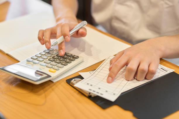 A Japanese chef working on a calculator stock photo