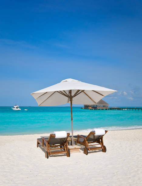 istock beach chairs with white umbrella at the ocean front 2199762894