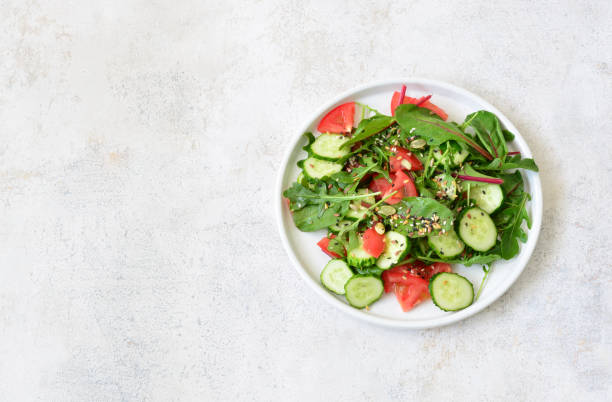 istock Fresh Summer Salad with greenery, tomato and cucumber slices top view 2199764438