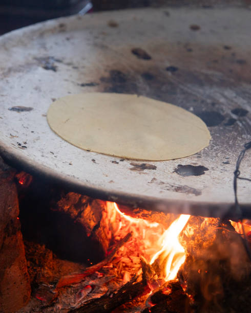 istock Cooking handmade corn tortillas on a traditional comal in an open fire kitchen in Oaxaca Mexico. 2199764753