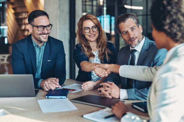istock Business persons shaking hands across the table 2199765339