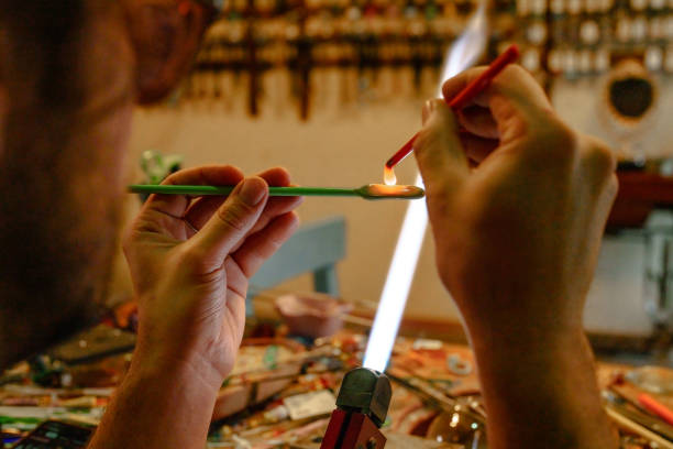 Crafting small glass pieces with flaming torch.