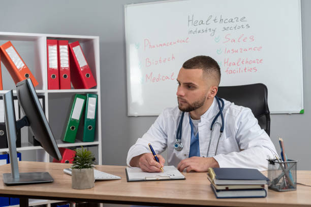 istock Young doctor or e general practitioner physician work in patient files at office medical clinic 2199778139