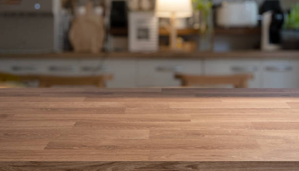 istock Empty wooden table top, counter, desk background with and blurred kitchen room background 2199782244
