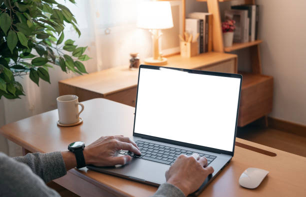 istock Close-up image of a man working on laptop computer at a table, typing on the laptop keyboard. the laptop with a white screen mockup 2199783220