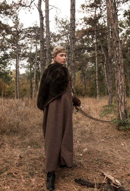 istock warrior girl with sword in hands in forest. 2199783535