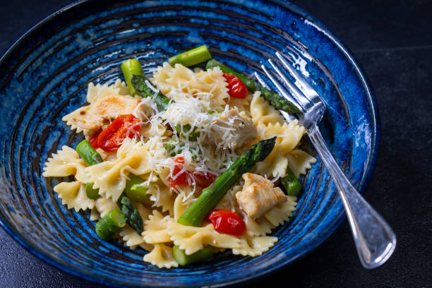 istock Farfalle pasta with green asparagus, cherry tomatoes and chicken 2199786628