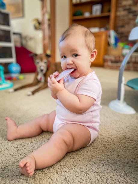 istock Baby sitting on floor eating snack 2199788135