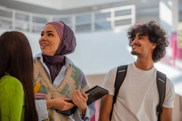istock A group of happy diverse college students hanging out they are talking with each other while walking in the university hallway. 2199788144