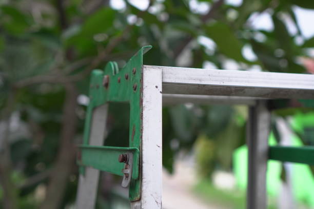 Metal Ladder Hinge Mechanism. This detailed photograph showcases the structural components of a metal ladder hinge. The image emphasizes the engineering and construction of this essential hardware. Suitable for technical publications, construction industry websites, or projects needing a focus on mechanical parts and engineering visuals.