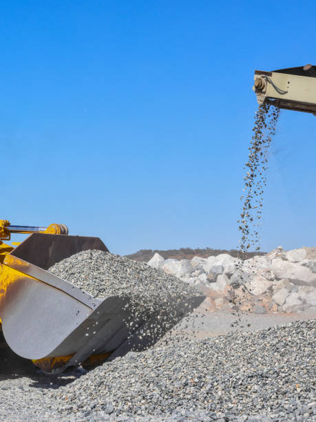istock Front end loader (bucket loader, payloader, high lift, scoop, shovel dozer, skid steer, skip loader, tractor loader, wheel loader) moving ore, gravel from stockpile, mine, quarry. Outback Australia. Conveyor belt 2199791255