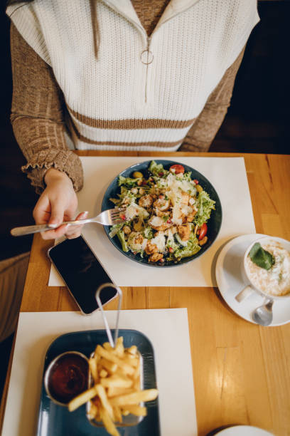 istock Young woman having salad meal in coffee shop 2199792425
