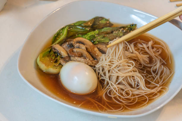 istock Steaming Ramen Bowl with Chopsticks on Wooden Table 2199793723