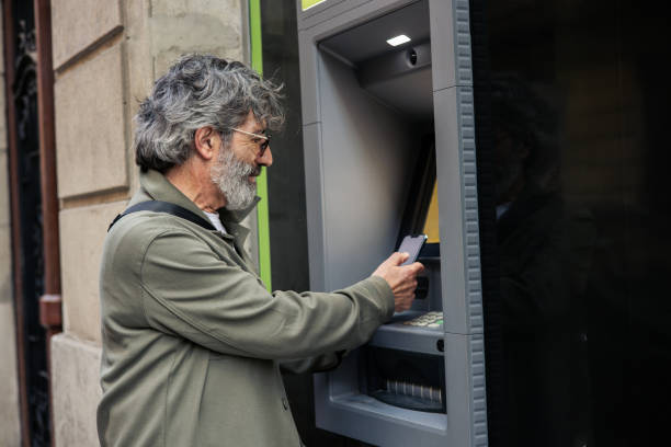 istock Mature man on a vacation taking the money from the ATM 2199802491