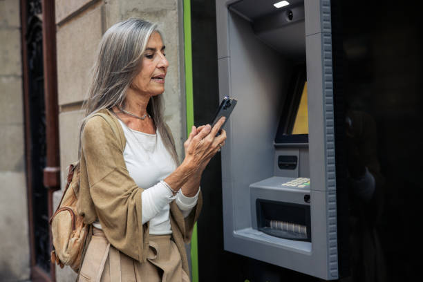 istock Mature woman on a vacation using the ATM 2199802500