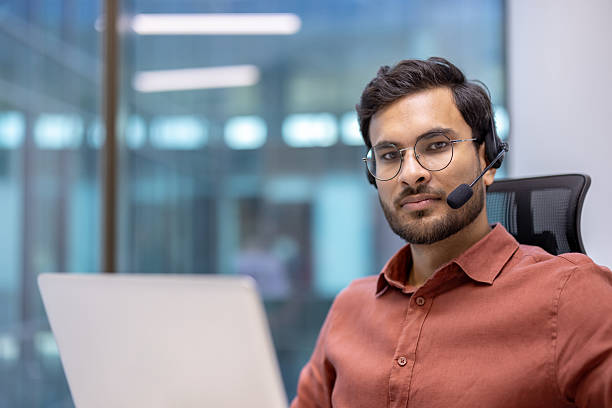 istock Latin American man businessman wearing headset working in modern office environment with laptop, focused on task, offering professional support and communication for customer service 2199803514