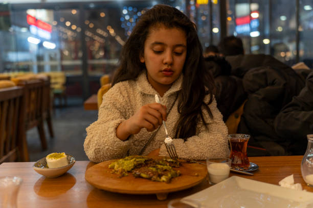 istock A girl is eating dessert in a cafe at night. 2199803691