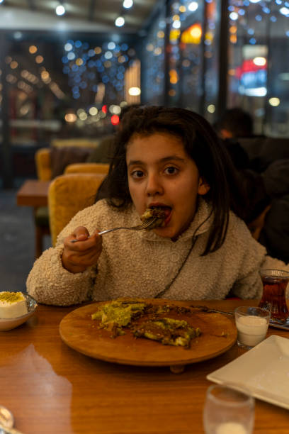 istock A girl is eating dessert in a cafe at night. 2199803692