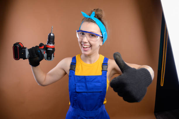 istock Caucasian female construction worker showing thumb up at final stage of site reconstruction. Happy white young woman worker in safety glasses and gloves with close-up gesture of admiration 2199809278