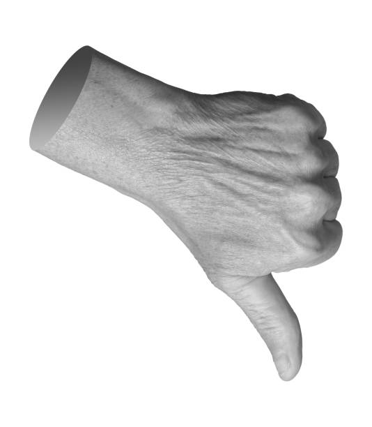 istock Elderly hand showing a thumbs-down gesture, symbolizing disapproval, rejection, and disagreement. 2199809399