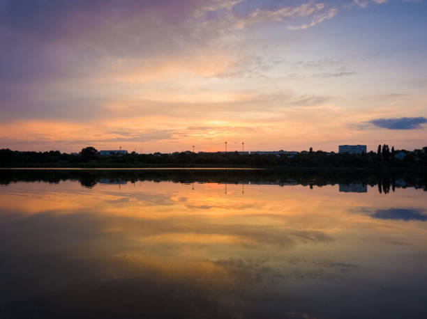 istock Colorful sunset clouds symmetric reflected on the lake surface. Idyllic summer evening, natural scene near a countryside pond with calm water 2199813652