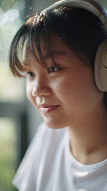 istock Teenager using laptop while wearing headphones. 2199815093