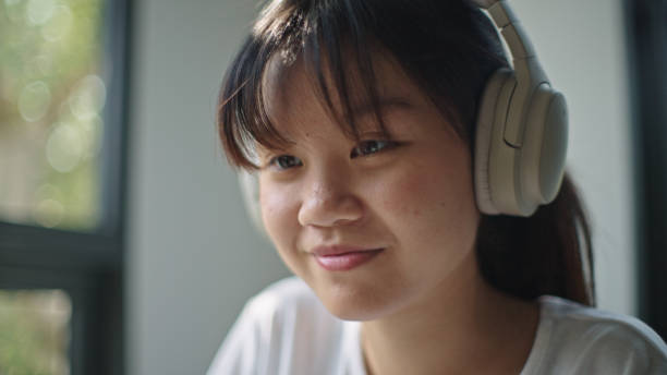 istock Teenager using laptop while wearing headphones. 2199816876