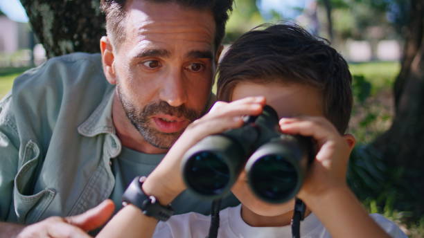 istock Family exploring new places looking binoculars birdwatching on nature closeup. 2199817032