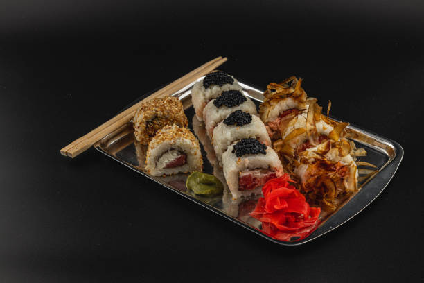 istock Sushi platter featuring assorted rolls with garnishes and chopsticks 2199817124