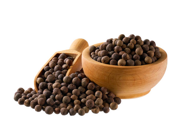 Wooden bowl with allspice or Jamaican pepper isolated on white background. allspice or Jamaican pepper seeds in a wooden bowl isolated on white background. allspice stock pictures, royalty-free photos & images