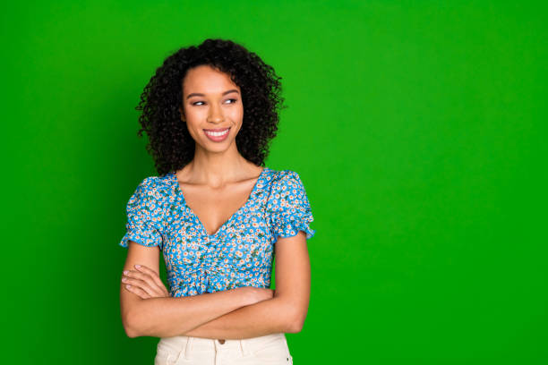 istock Photo of positive funky lady dressed blue top smiling arms folded looking empty space isolated green color background 2199826110