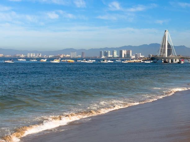 Chairs with tables under umbrellas on the beach facing the sea, in Puerto Vallarta, Jalisco