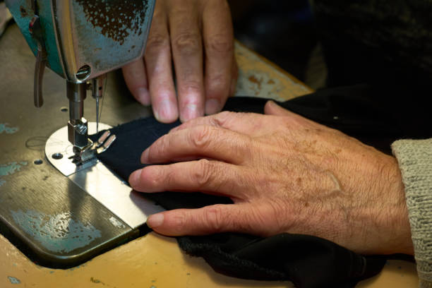 istock Working hands of a tailor on a sewing machine 2199827528