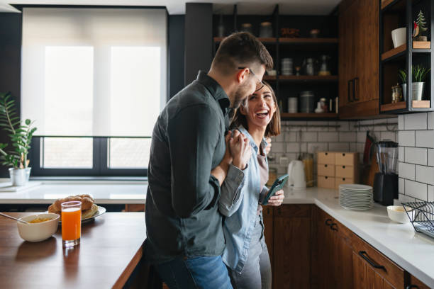 istock Young couple laughing and holding hands in the kitchen 2199831511