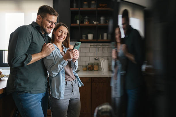 istock Young couple looking at smartphone in modern kitchen 2199831518