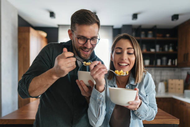istock Happy couple eating cereals for breakfast in the kitchen 2199831541