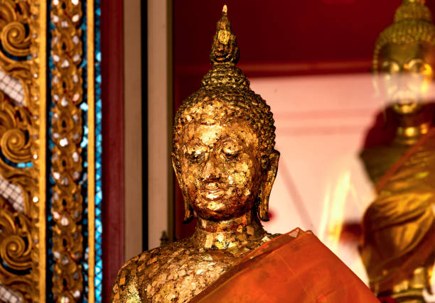 istock Buddha figure with red robe covered in gold foil 2199835579
