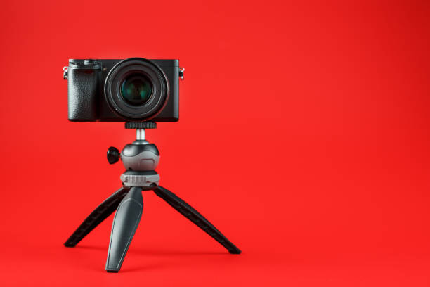 istock Photo video camera with a tripod, on a red background. 2199835967