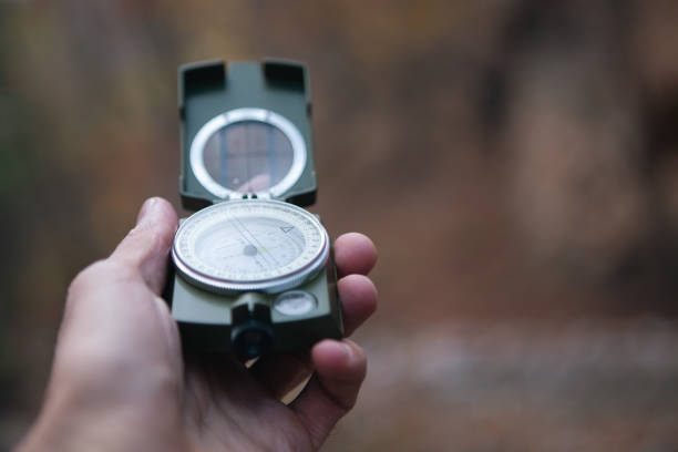istock hand holding compass on a background of the forest. 2199837164