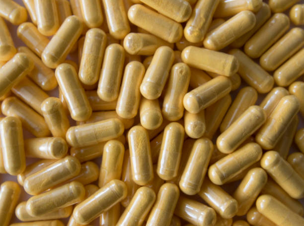 istock Yellow tablets or pills on the black stone background. 2199838252