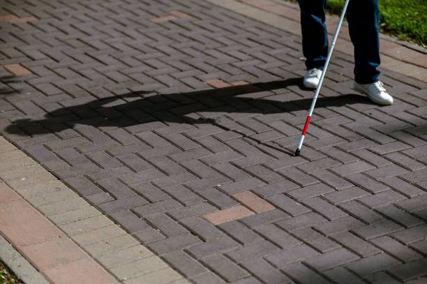 istock A faceless blind woman walks down the street with a cane. 2199839287