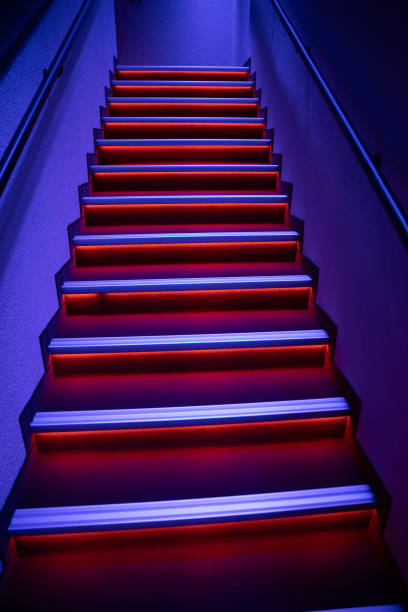 A visually striking and captivating staircase that is beautifully illuminated with dynamic blue and red lights