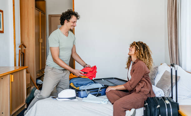 istock Couple unpacking luggage in a hotel room 2199842014