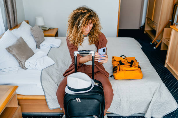 istock Woman using phone in a hotel room 2199842021